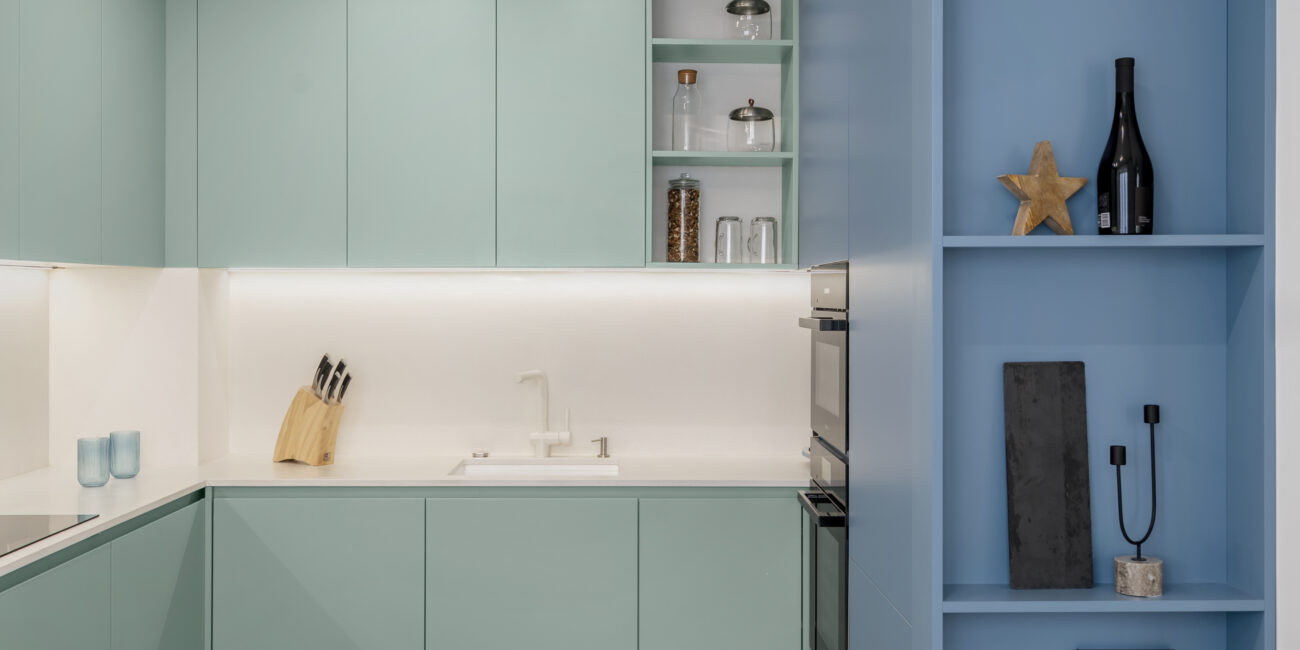Интериорен дизайн на кухня в синьо и пастелно зелено с плот от технически камък в кв. Изток